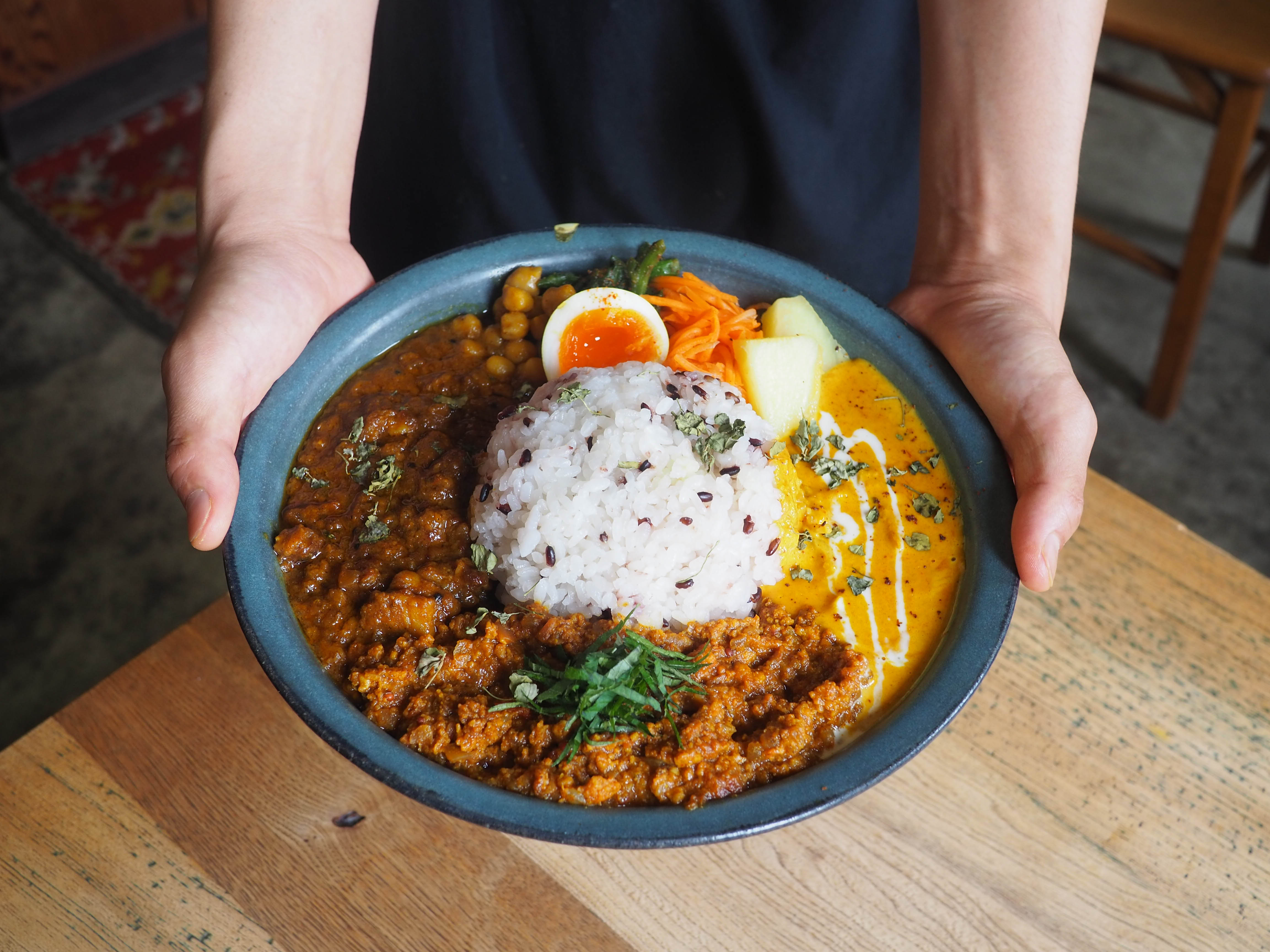 スパイスカレーを両手で持っている写真